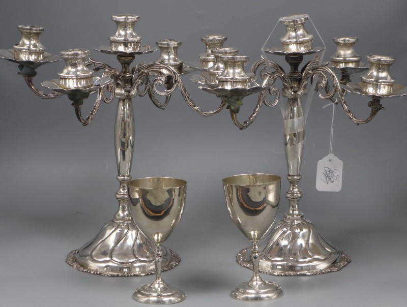 A pair of continental 900 standard white metal candelabra(a.f.) height 34cm and a pair of sterling goblets, gross weight 146.5oz.